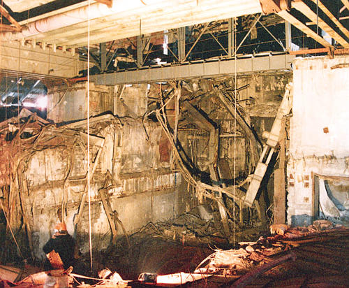 Artur Korneev, Deputy Director of Shelter, viewing a
	    portion of the Central Reactor Hall showing cylindrical
	    pipe roof members, Mammoth Beams and portions of the
	    destroyed refuelling machine, Chornobyl NPP. Photographer:
	    Unknown. Spring 1997.  [US DOE]